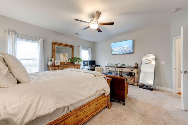 carpeted bedroom with ceiling fan and multiple windows