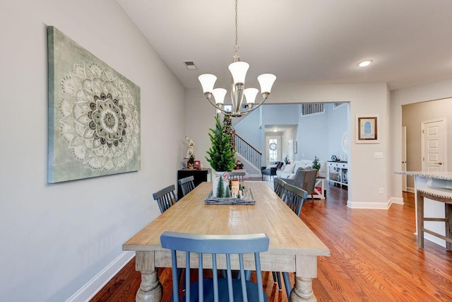 dining space featuring a notable chandelier and wood-type flooring