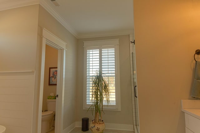 bathroom featuring a shower with door, vanity, ornamental molding, and toilet