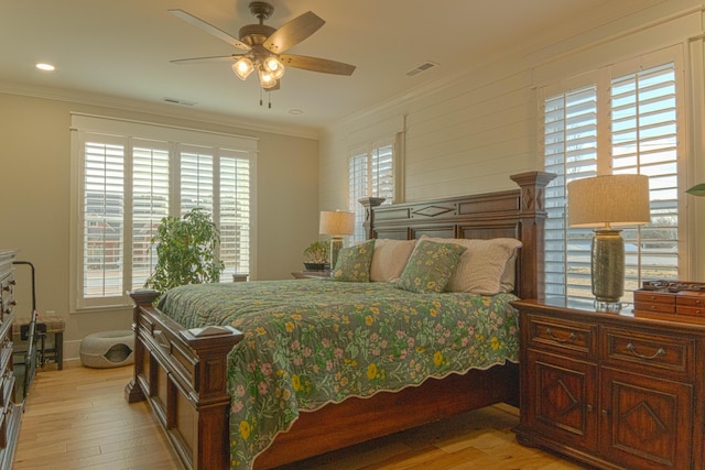 bedroom with ceiling fan, ornamental molding, light hardwood / wood-style flooring, and multiple windows