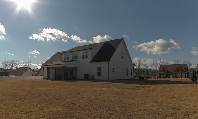 rear view of property featuring a sunroom and central AC unit