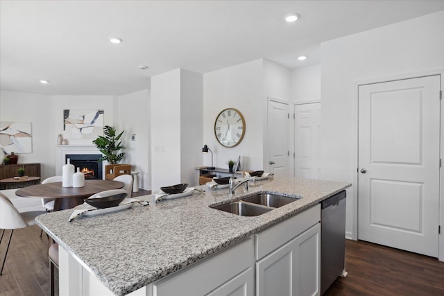 kitchen featuring dishwasher, a center island with sink, sink, dark hardwood / wood-style flooring, and white cabinetry