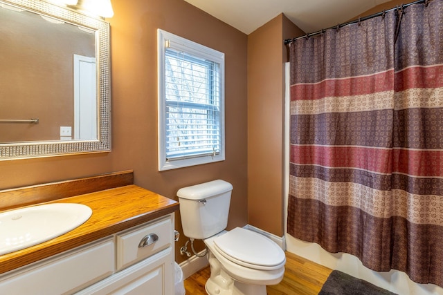 bathroom with hardwood / wood-style flooring, curtained shower, toilet, and vanity