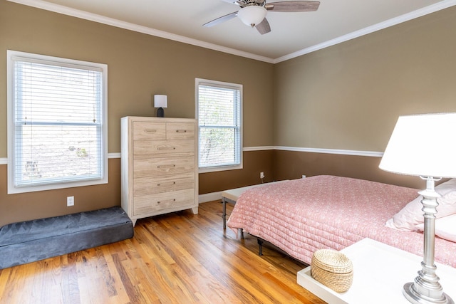 bedroom featuring ceiling fan, wood-type flooring, and crown molding