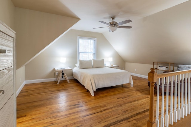 bedroom with ceiling fan, wood-type flooring, and vaulted ceiling