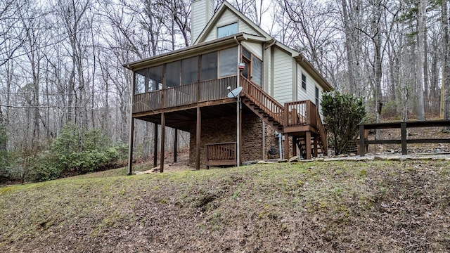 rear view of house featuring a sunroom