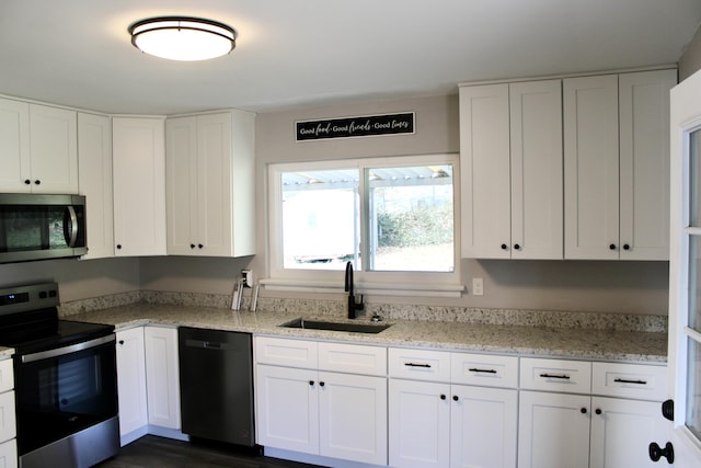 kitchen featuring light stone countertops, stainless steel appliances, dark wood-type flooring, sink, and white cabinetry