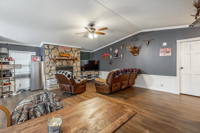 living room featuring hardwood / wood-style floors, lofted ceiling, and ornamental molding