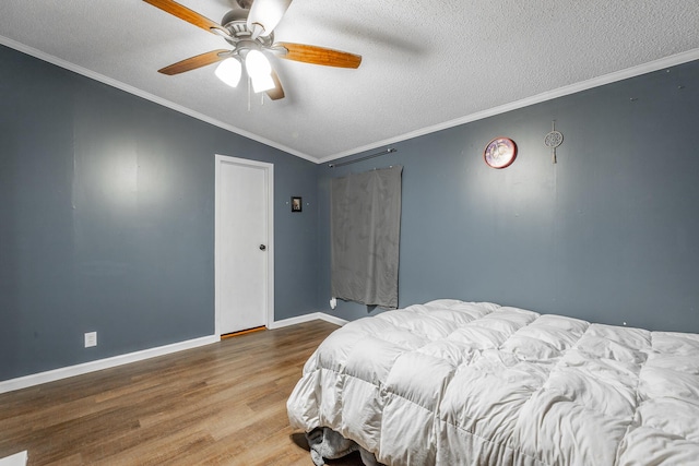 bedroom with a textured ceiling, hardwood / wood-style flooring, ceiling fan, and crown molding