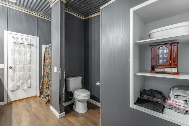 bathroom with hardwood / wood-style flooring and toilet