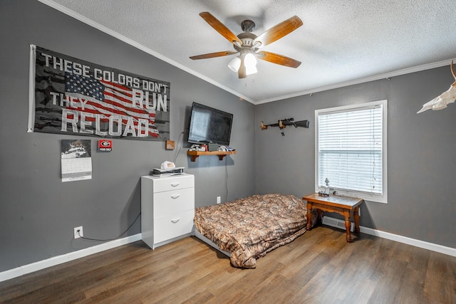 bedroom with wood-type flooring, a textured ceiling, ceiling fan, and ornamental molding