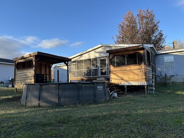 back of house featuring a yard and a sunroom