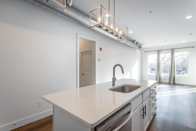 kitchen featuring sink, stainless steel dishwasher, pendant lighting, a kitchen island with sink, and white cabinets