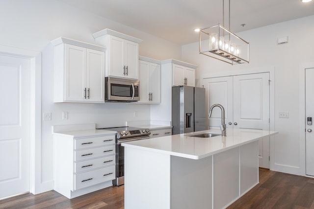 kitchen featuring stainless steel appliances, decorative light fixtures, a center island with sink, white cabinets, and dark hardwood / wood-style floors