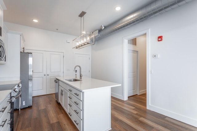 kitchen with sink, dark hardwood / wood-style floors, an island with sink, appliances with stainless steel finishes, and white cabinetry