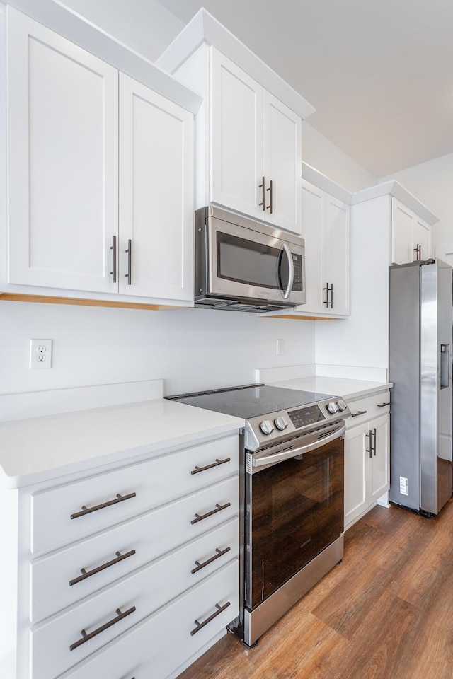 kitchen featuring white cabinetry, dark hardwood / wood-style flooring, and appliances with stainless steel finishes