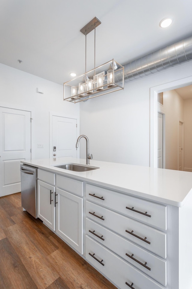 kitchen featuring sink, stainless steel dishwasher, wood-type flooring, decorative light fixtures, and white cabinets