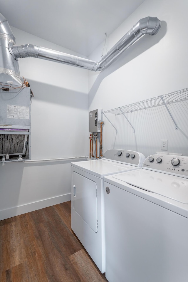 washroom with washing machine and clothes dryer and dark hardwood / wood-style floors