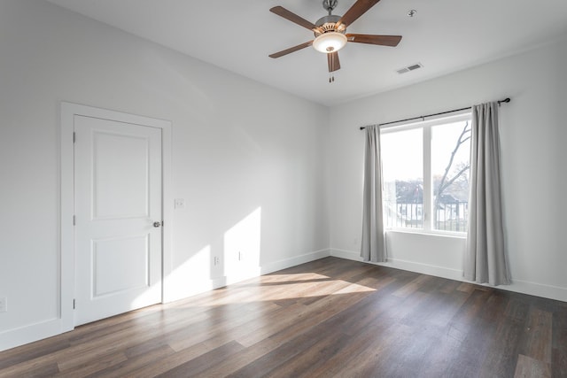 empty room featuring ceiling fan and dark hardwood / wood-style flooring