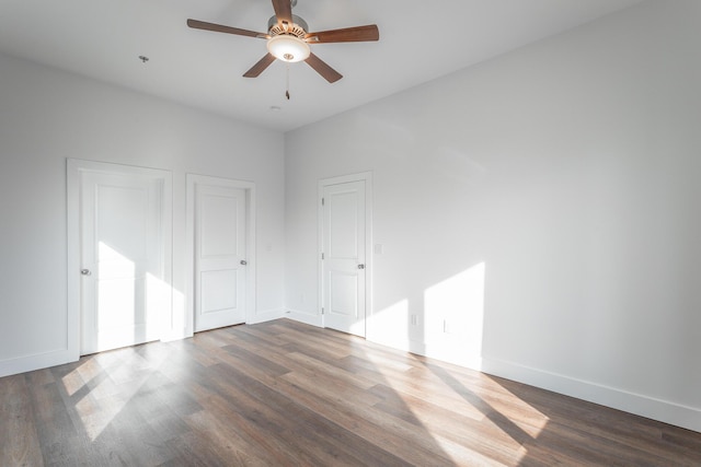 empty room featuring ceiling fan and dark wood-type flooring