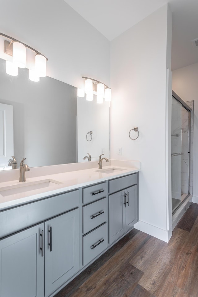 bathroom with vanity, wood-type flooring, and an enclosed shower