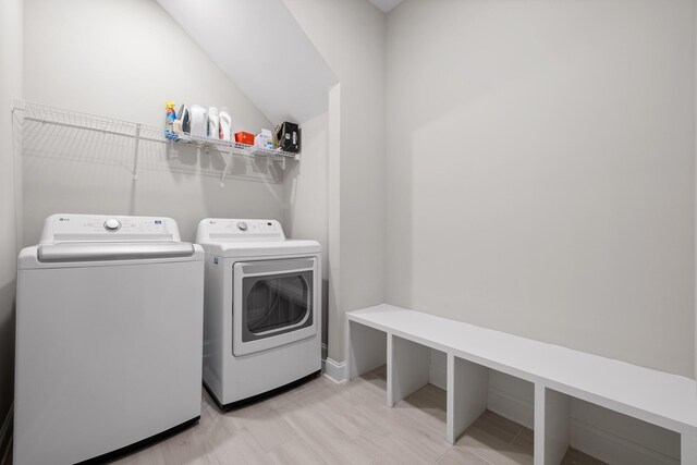 laundry area with light wood-type flooring and separate washer and dryer