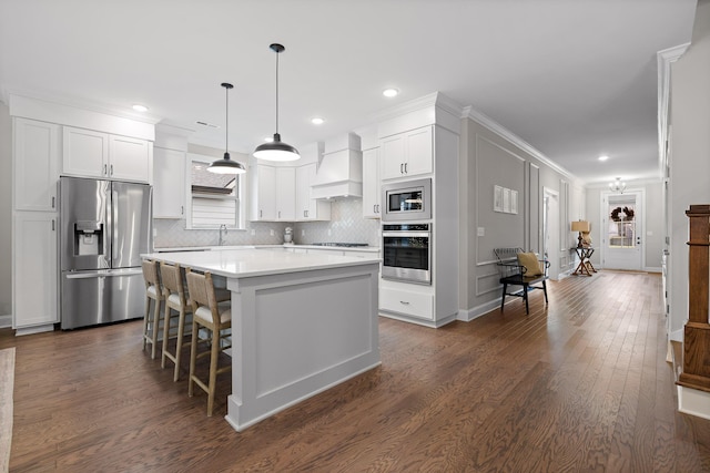 kitchen with pendant lighting, premium range hood, a kitchen island, dark hardwood / wood-style flooring, and stainless steel appliances