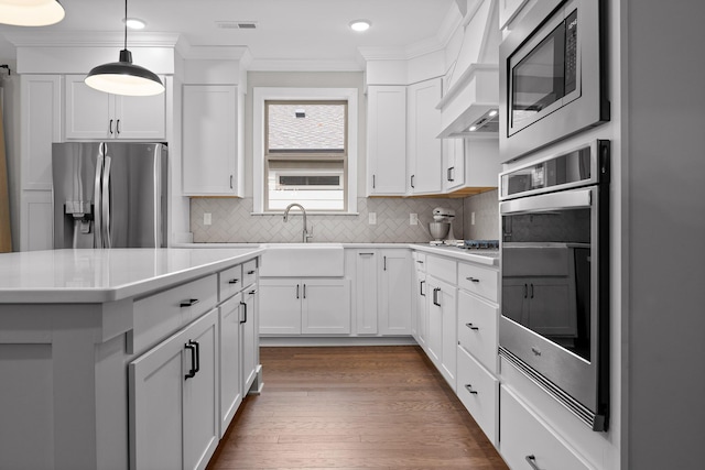 kitchen featuring sink, hanging light fixtures, dark hardwood / wood-style flooring, white cabinets, and appliances with stainless steel finishes