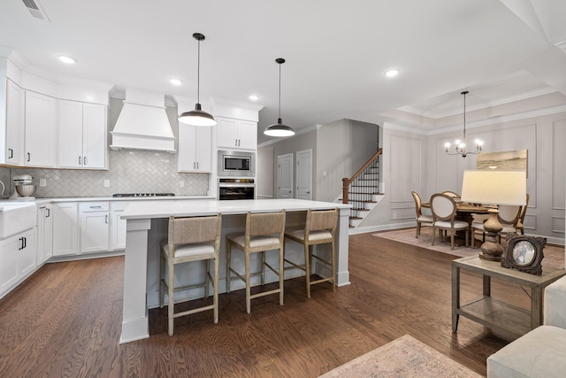 kitchen with appliances with stainless steel finishes, dark hardwood / wood-style floors, pendant lighting, and custom exhaust hood