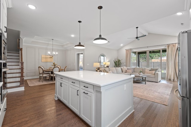 kitchen with lofted ceiling, dark hardwood / wood-style floors, stainless steel fridge, a kitchen island, and white cabinetry