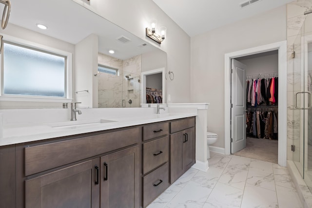 bathroom with vanity, toilet, and a shower with door