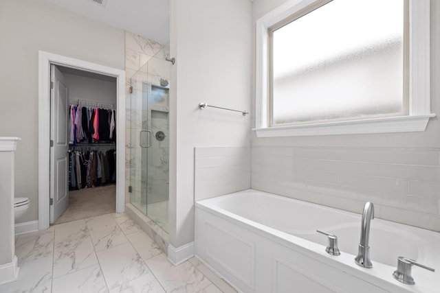 bathroom with separate shower and tub, toilet, and a wealth of natural light