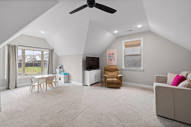 interior space with ceiling fan, light colored carpet, and vaulted ceiling