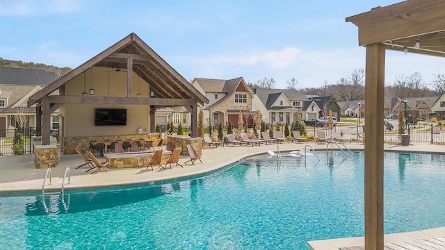 view of pool featuring a patio and exterior fireplace