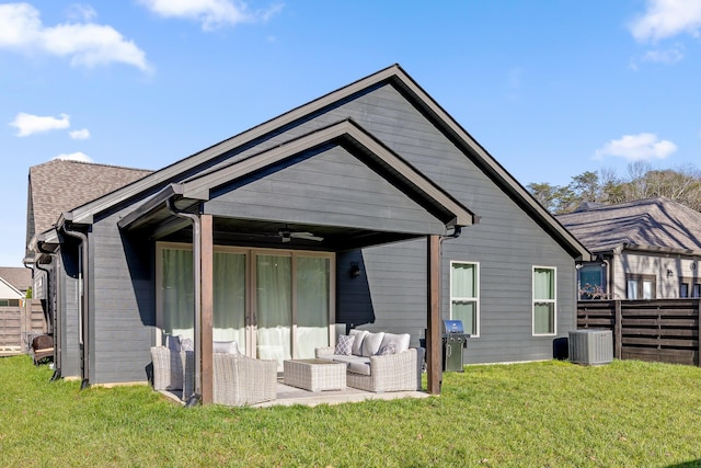 rear view of property featuring outdoor lounge area, central air condition unit, ceiling fan, and a lawn