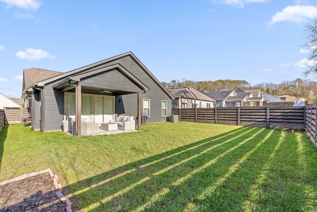 rear view of house with outdoor lounge area, ceiling fan, and a lawn