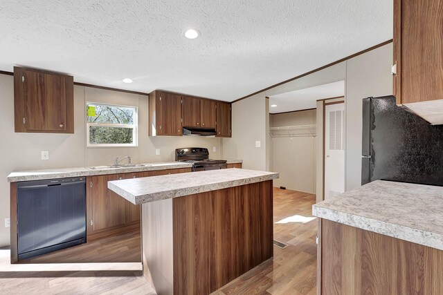 kitchen with ornamental molding, sink, light wood-type flooring, and black appliances