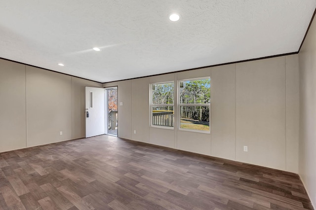 spare room with crown molding, wood-type flooring, and a textured ceiling