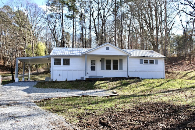 view of front of home featuring a carport, covered porch, and a front lawn