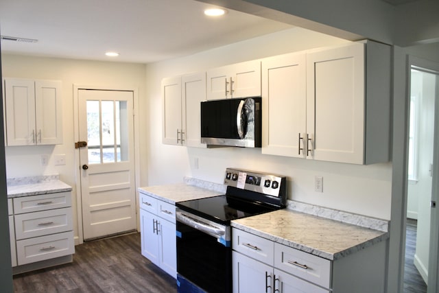 kitchen with light stone counters, dark hardwood / wood-style flooring, white cabinets, and appliances with stainless steel finishes