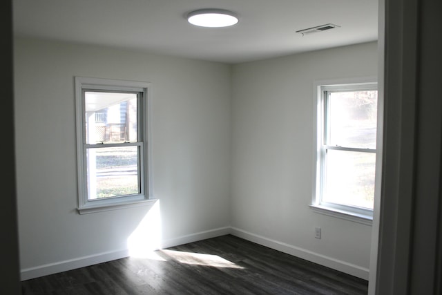 unfurnished room featuring dark hardwood / wood-style flooring and plenty of natural light