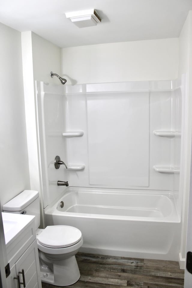 full bathroom featuring toilet, vanity, hardwood / wood-style flooring, and bathing tub / shower combination