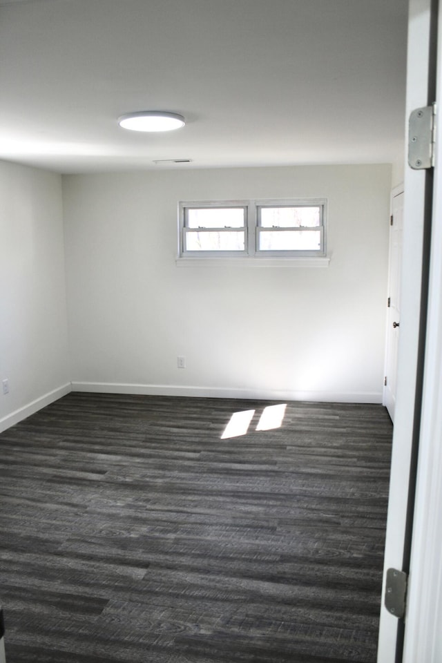 unfurnished room with dark wood-type flooring