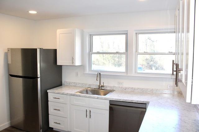 kitchen with stainless steel appliances, white cabinetry, and sink