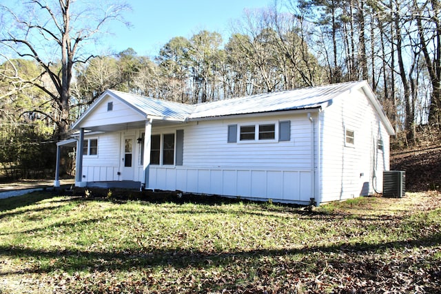 ranch-style home with a front yard, cooling unit, and covered porch