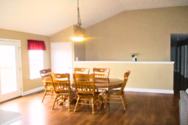 dining area featuring lofted ceiling and dark hardwood / wood-style flooring