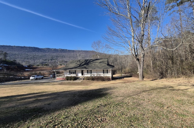 view of yard featuring a porch and a mountain view