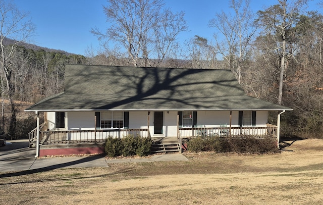 farmhouse-style home with covered porch and a front yard