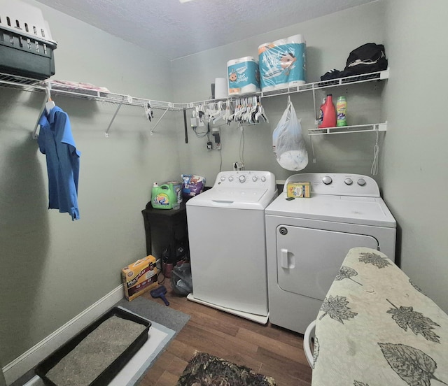 laundry area featuring a textured ceiling, separate washer and dryer, and dark hardwood / wood-style floors