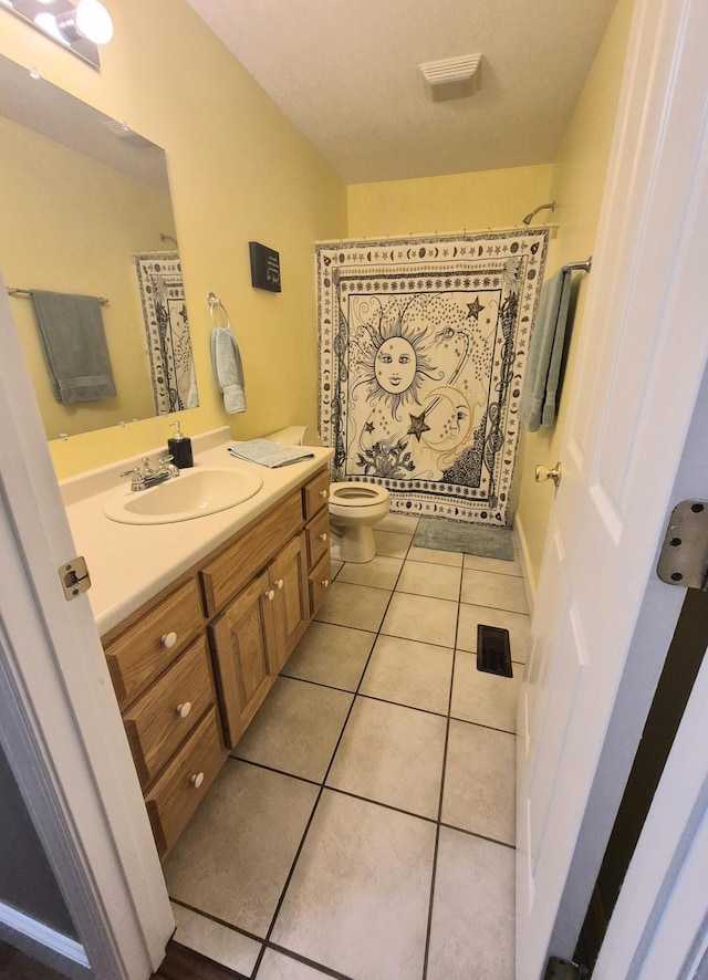 bathroom featuring curtained shower, tile patterned flooring, vanity, and toilet